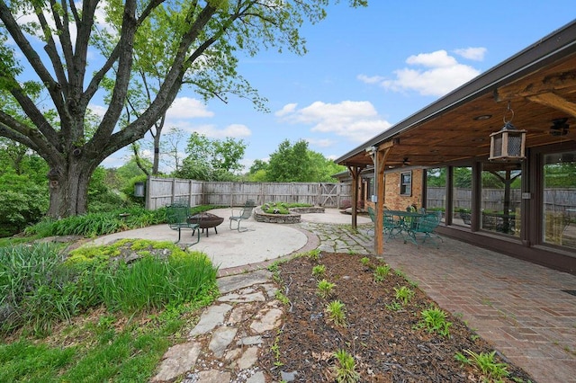 fenced backyard with a fire pit, a patio area, and a ceiling fan