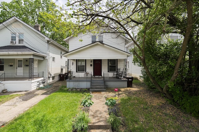 view of front of house with a front yard and a porch