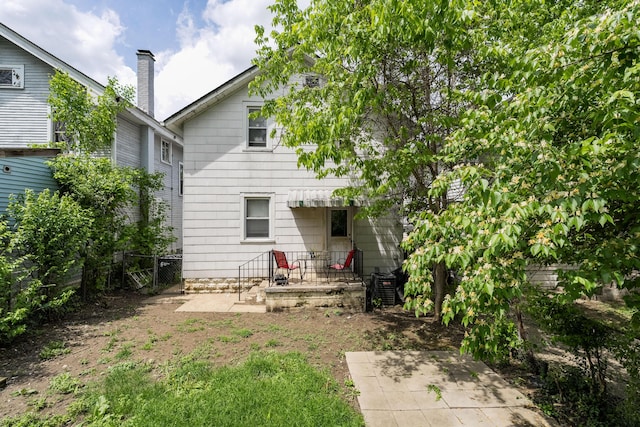 rear view of house with central AC unit, fence, and a patio