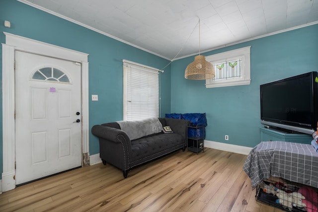 living area with ornamental molding, baseboards, and wood finished floors