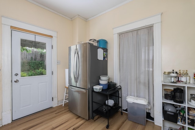 kitchen featuring freestanding refrigerator, light wood-style flooring, and ornamental molding