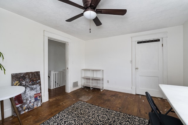 interior space featuring a ceiling fan, a textured ceiling, hardwood / wood-style floors, and visible vents
