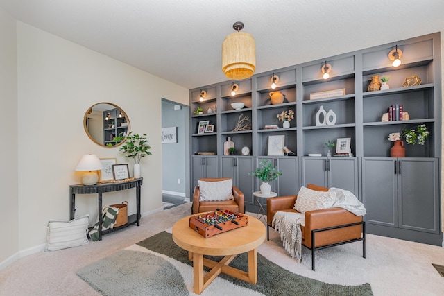 sitting room featuring light carpet, baseboards, and built in features