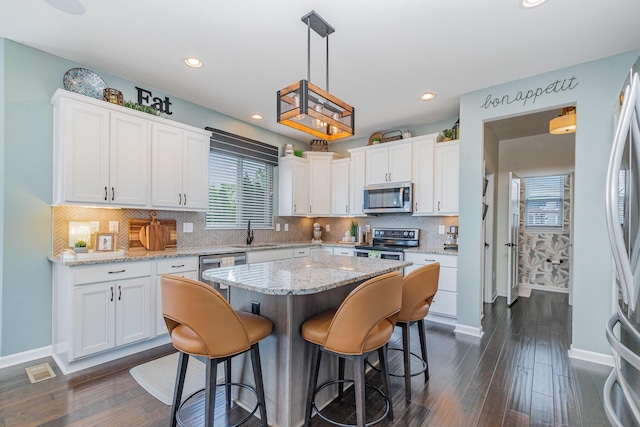kitchen featuring appliances with stainless steel finishes, white cabinetry, a sink, and recessed lighting