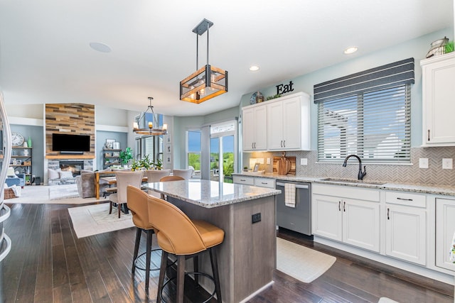 kitchen with a sink, dishwasher, white cabinets, a center island, and recessed lighting