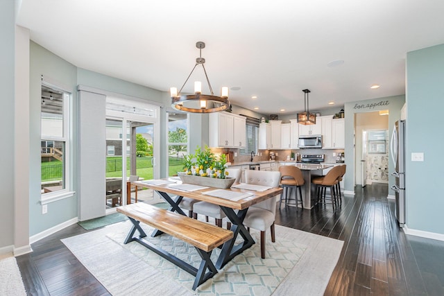 dining space with baseboards, a chandelier, dark wood-type flooring, and recessed lighting