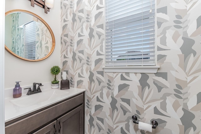 bathroom with wallpapered walls and vanity