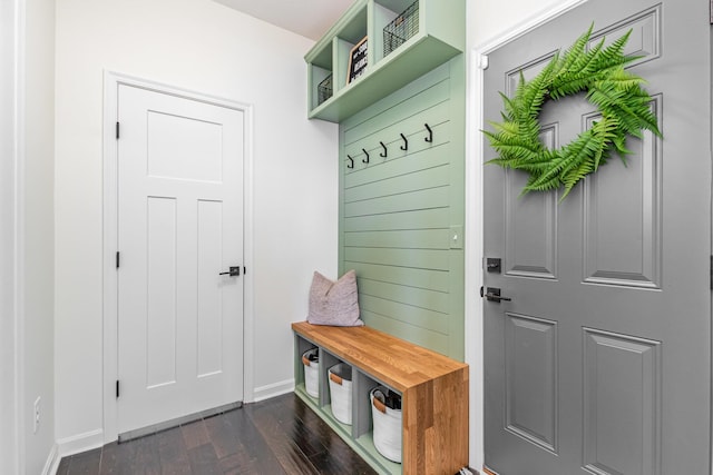 mudroom with dark wood finished floors and baseboards