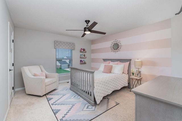 bedroom featuring light colored carpet, a ceiling fan, and baseboards