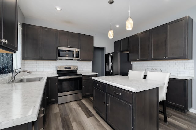 12062 Ambruzzi Dr, Walton, KY 41094 - kitchen with stainless steel appliances, a sink, a center island, dark wood-style floors, and backsplash