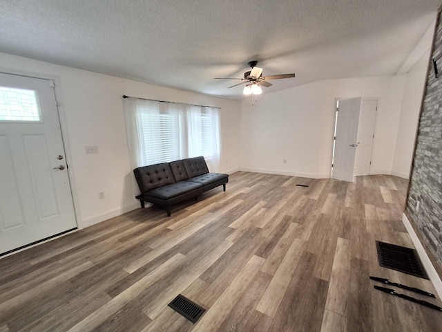 interior space with a ceiling fan, visible vents, and a textured ceiling