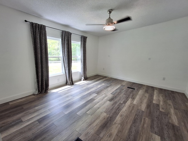 spare room with a ceiling fan, baseboards, a textured ceiling, and wood finished floors