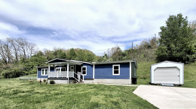 manufactured / mobile home with a front lawn, an outdoor structure, and covered porch