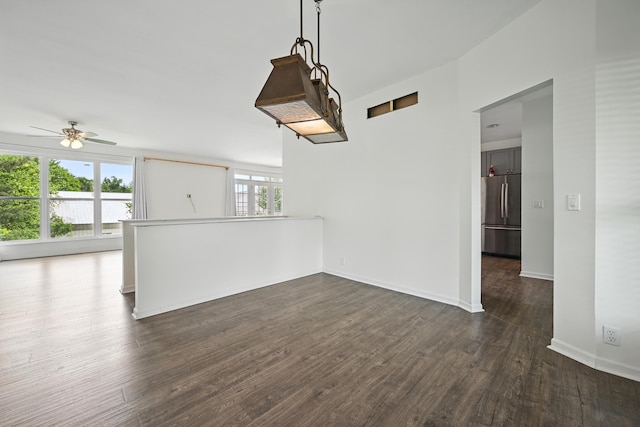 unfurnished room featuring ceiling fan, dark wood-style floors, and baseboards