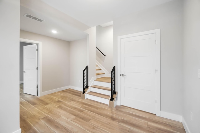 staircase with baseboards, recessed lighting, visible vents, and wood finished floors
