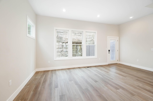 spare room featuring baseboards, light wood finished floors, and recessed lighting