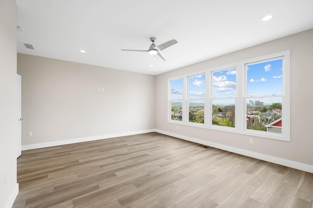 spare room featuring a ceiling fan, recessed lighting, baseboards, visible vents, and light wood-type flooring