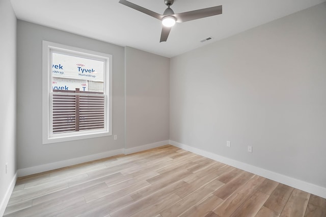 spare room with ceiling fan, light wood-style flooring, baseboards, and visible vents