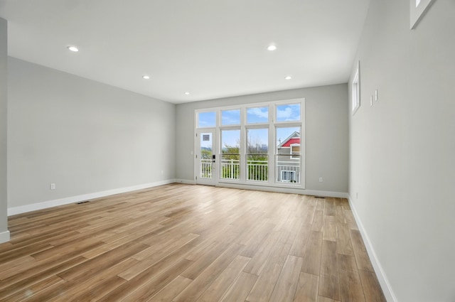spare room with recessed lighting, baseboards, and light wood-style floors