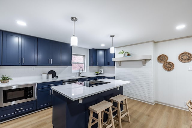 kitchen with built in microwave, a sink, a kitchen bar, blue cabinetry, and black electric stovetop