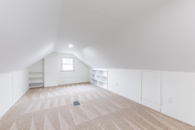 additional living space featuring lofted ceiling, visible vents, carpet, and built in shelves