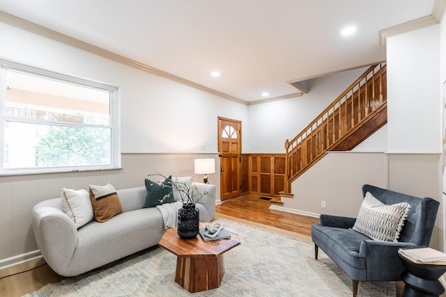 living room with stairs, ornamental molding, recessed lighting, wainscoting, and light wood-style floors