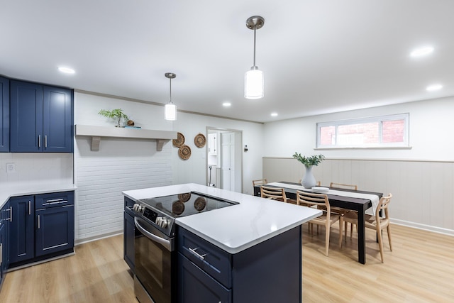 kitchen featuring stainless steel range with electric stovetop, light countertops, light wood-style flooring, and blue cabinetry