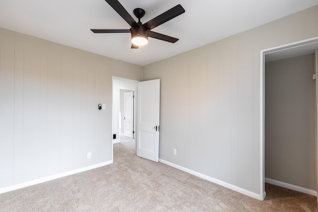 unfurnished bedroom featuring carpet floors, baseboards, and a ceiling fan