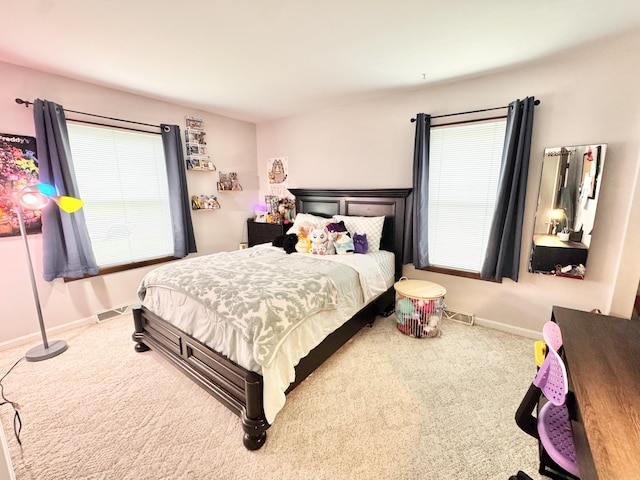carpeted bedroom with multiple windows, visible vents, and baseboards