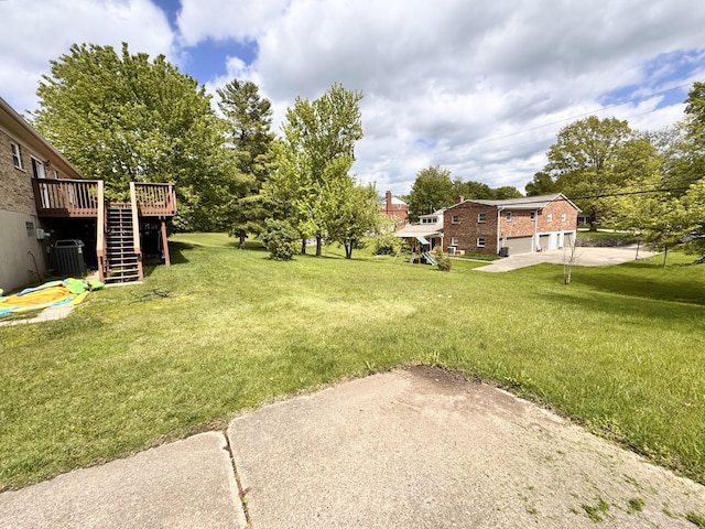 view of yard with central air condition unit, stairway, and a wooden deck
