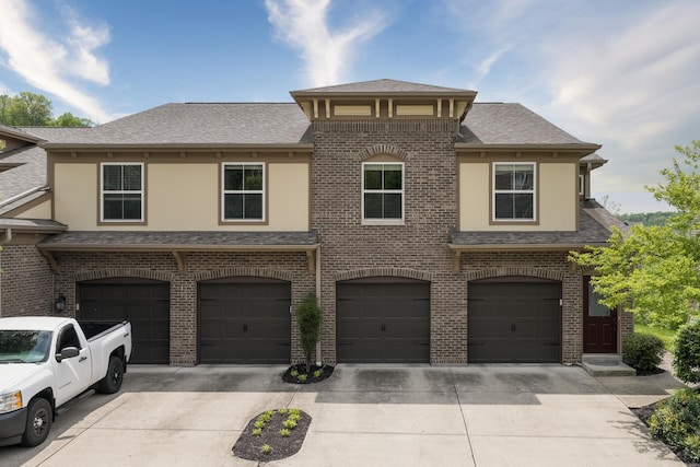 2387 Ambrato Way Unit 2-307, Covington, KY 41017 - view of front of property featuring driveway, a garage, stucco siding, a shingled roof, and brick siding