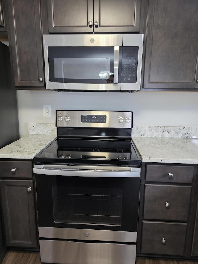 2964 Holly Hill Dr, Burlington, KY 41005 - kitchen featuring light stone countertops, stainless steel appliances, dark brown cabinetry, and wood finished floors
