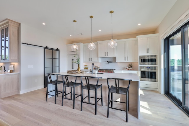 1200 Vistapointe Dr, Covington, KY 41011 - kitchen featuring a barn door, light wood-style floors, a kitchen breakfast bar, light countertops, and recessed lighting