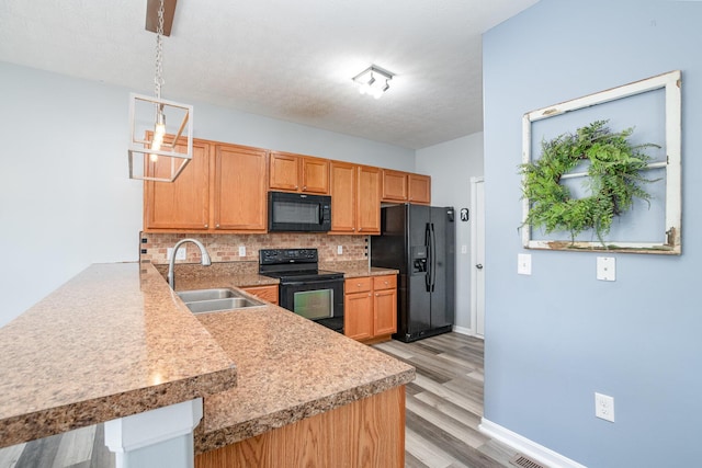 47 Nicole Dr, Independence, KY 41051 - kitchen with black appliances, a sink, tasteful backsplash, light wood-style flooring, and a peninsula
