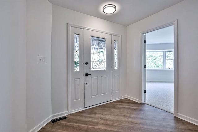 foyer featuring dark wood-type flooring and baseboards