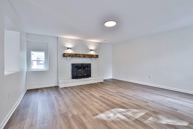 unfurnished living room featuring wood finished floors and baseboards