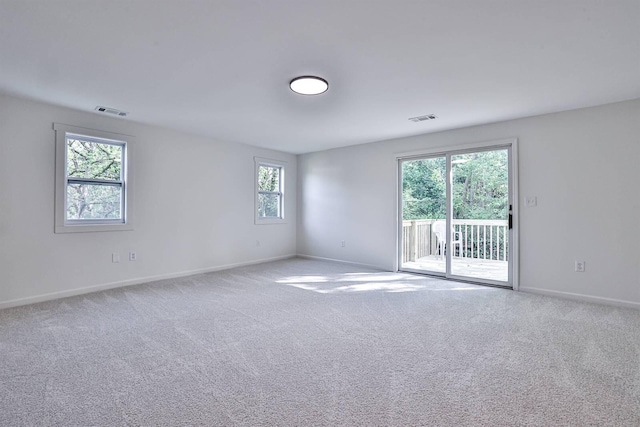 carpeted empty room featuring healthy amount of natural light and baseboards