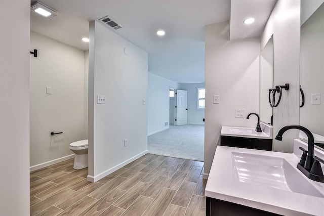 full bath with baseboards, wood finished floors, vanity, toilet, and recessed lighting