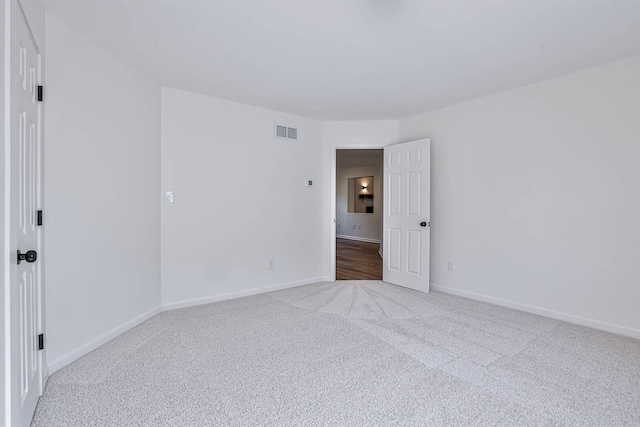 carpeted spare room featuring baseboards