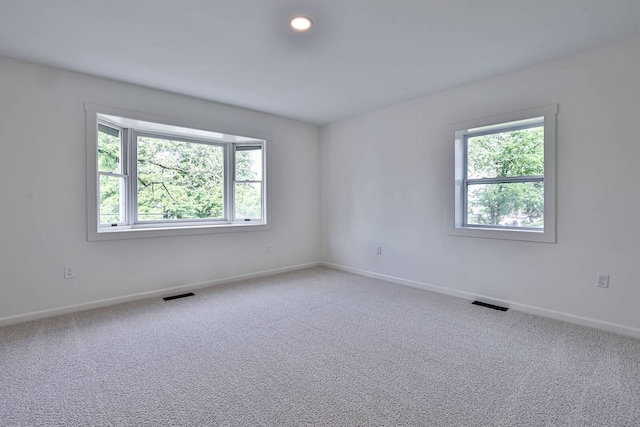 spare room with baseboards and carpet floors