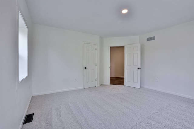 carpeted spare room featuring baseboards and recessed lighting