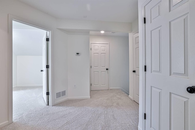 hallway featuring carpet and baseboards