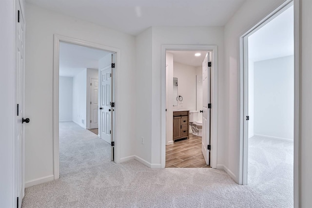 corridor featuring carpet floors and baseboards