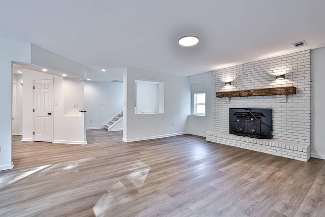 unfurnished living room featuring stairway, baseboards, wood finished floors, and recessed lighting