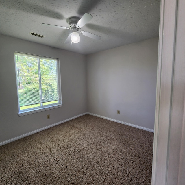 empty room with baseboards, carpet floors, a ceiling fan, and a textured ceiling