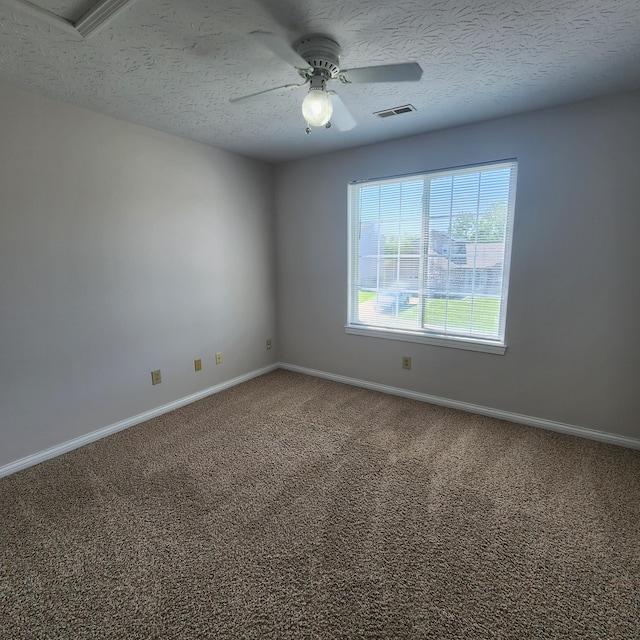 carpeted spare room with a ceiling fan, baseboards, and a textured ceiling