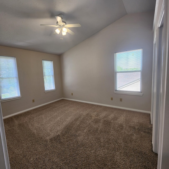 spare room featuring lofted ceiling, ceiling fan, carpet floors, healthy amount of natural light, and baseboards