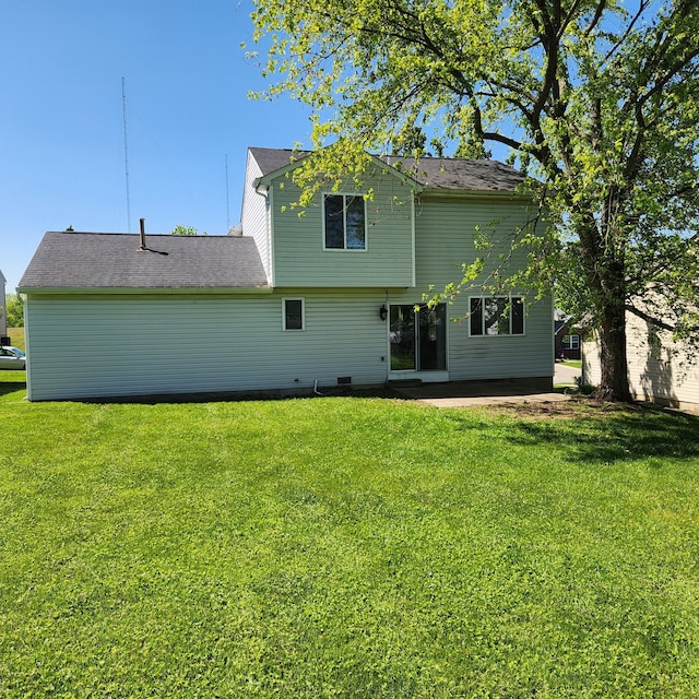 rear view of house featuring a yard and a patio