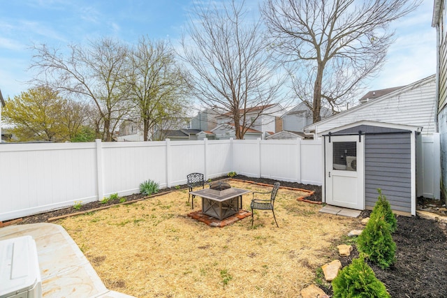 view of yard featuring a shed, an outdoor structure, and an outdoor fire pit