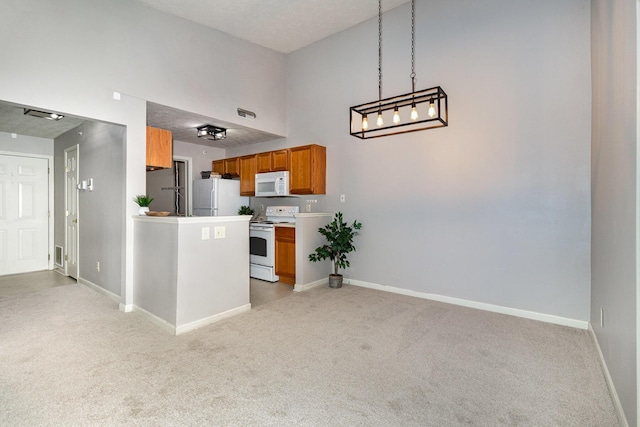 kitchen featuring white appliances, light carpet, baseboards, and a towering ceiling